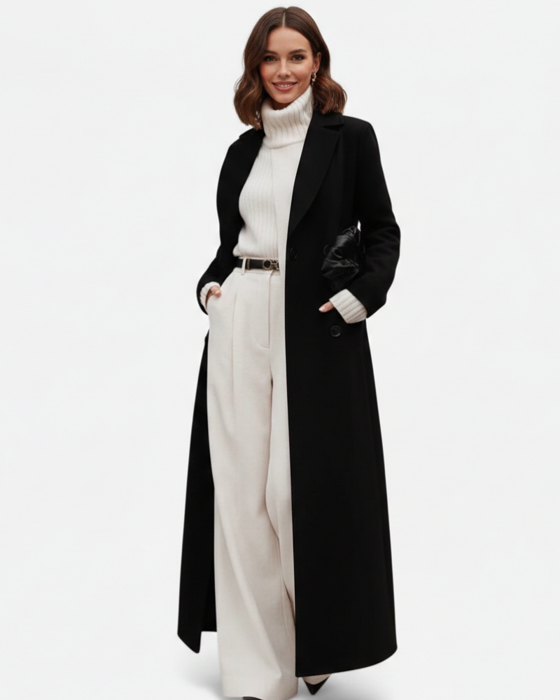 Femme portant un manteau long noir chic et polyvalent avec col revers, parfait pour mi-saison et l'hiver.