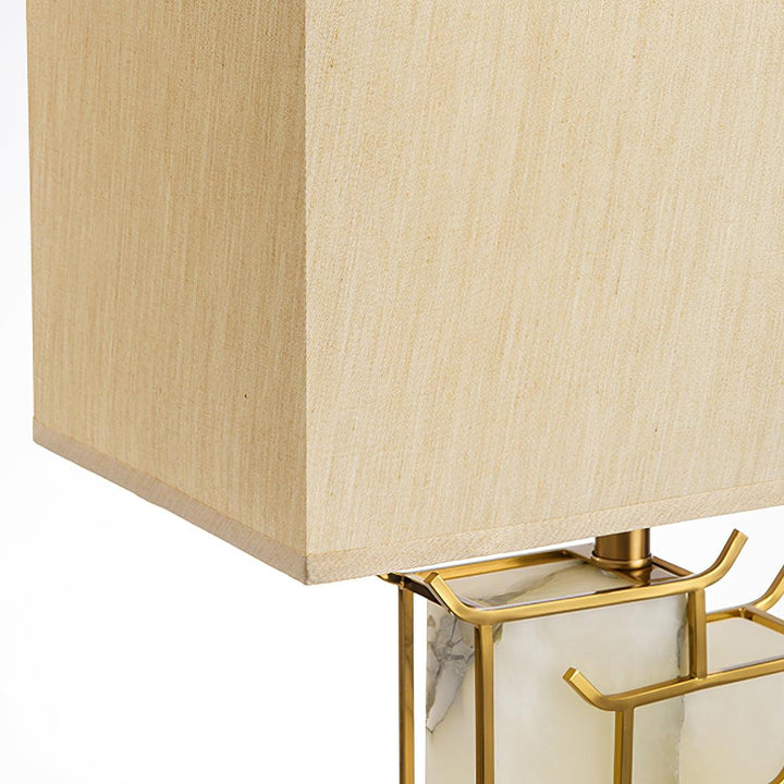 Lampe de table design, corps vertical doré, abat-jour rectangulaire albâtre blanc. Lumière d'ambiance.