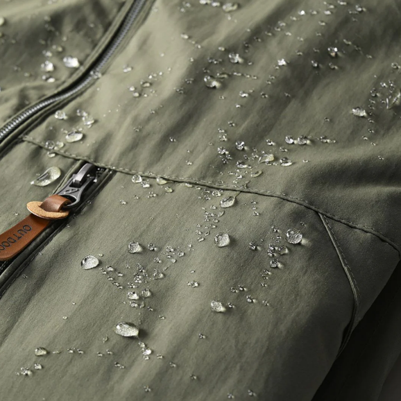 Homme portant une veste imperméable pour randonnée en montagne, protection sport et outdoor.