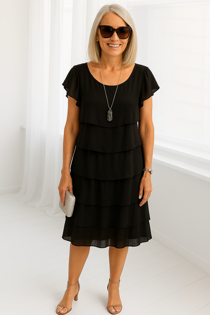 Tenue estivale élégante: robe midi femme à volants et manches courtes. Style fluide pour les chaudes journées d'été.