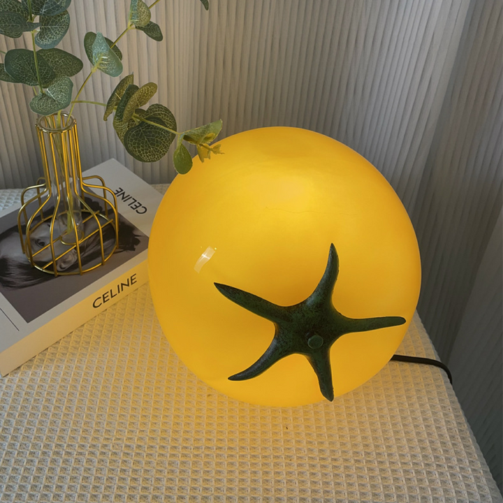 Lampe de table minimaliste style tomate jaune, apportant un design moderne et une lumière d'appoint.