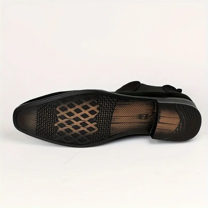 Détail d'une bottine Chelsea homme noire, mettant en valeur le cuir et les soufflets élastiques, pour un look chic.