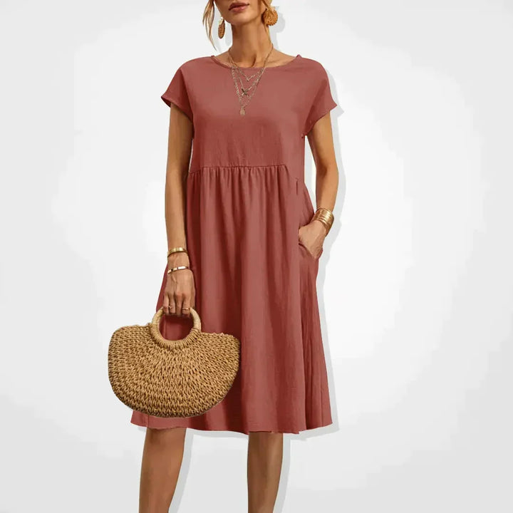 Robe femme confortable et décontractée, coupe empire. Manches courtes et poches pratiques pour l'été.
