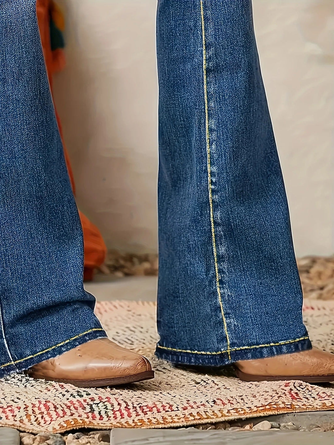 Détail de la coupe évasée et de la taille haute d'un jean femme en denim bleu, mode et confort.