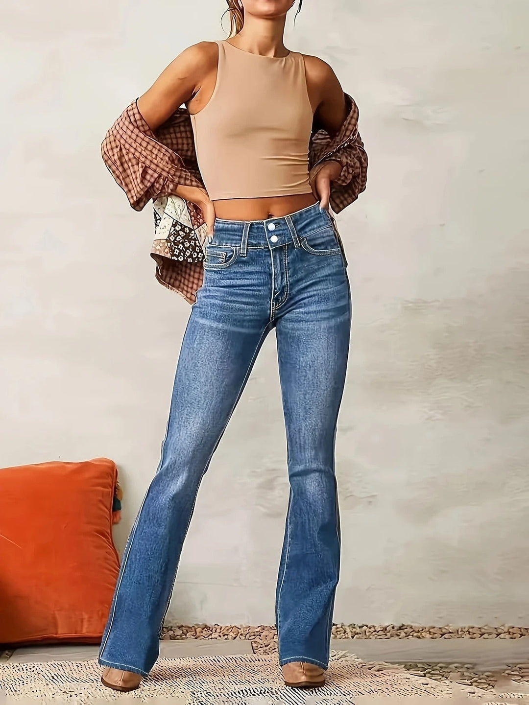 Vue de près du denim bleu des jeans évasés taille haute femme, avec les détails des 5 poches.