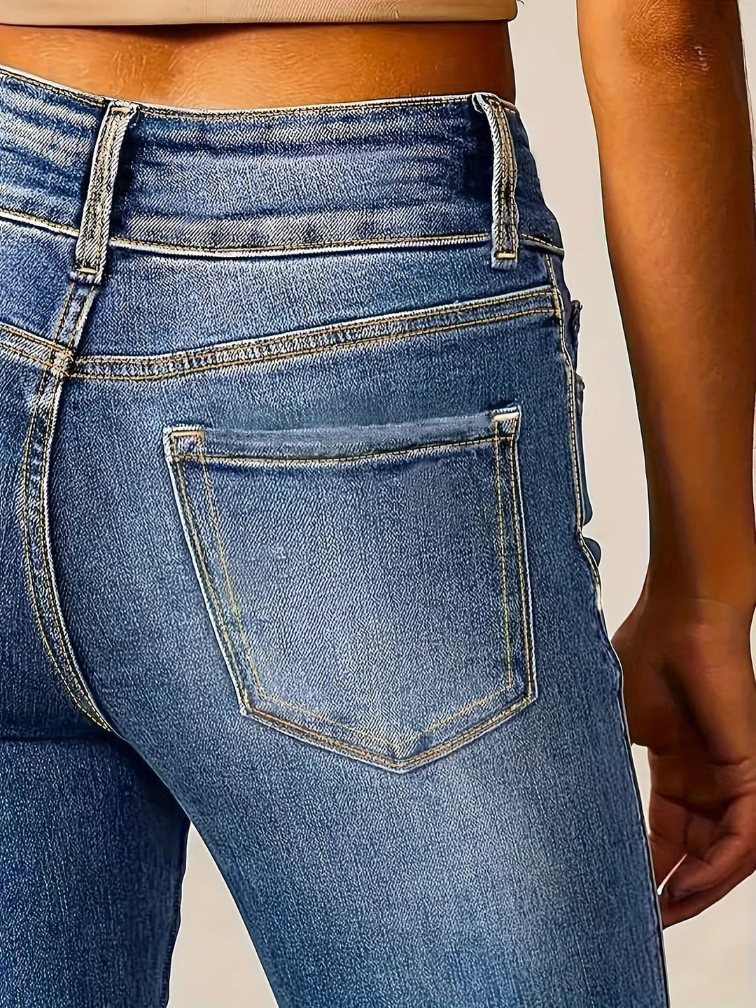Femme portant un jean évasé taille haute sculpté, denim bleu, offrant une allure chic et décontractée.