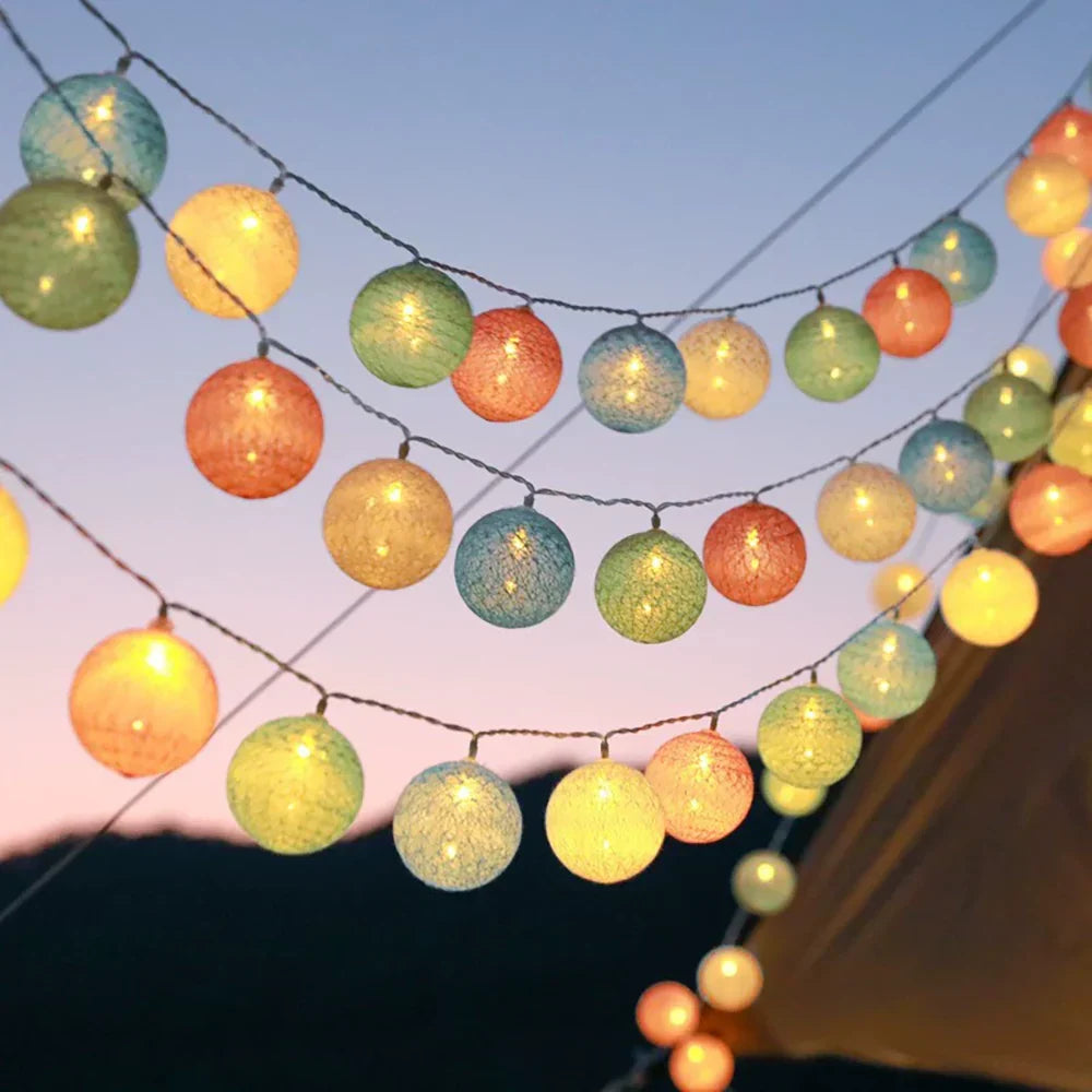 Guirlande lumineuse LED boules de coton sur un lit, ambiance cocooning et sereine.