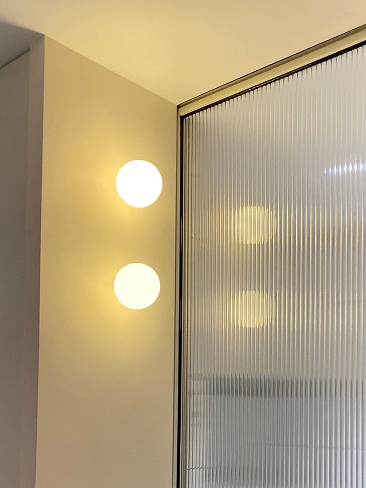 Éclairage mural LED moderne avec un globe en verre dépoli, parfait pour un intérieur contemporain.