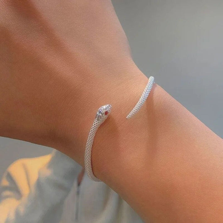Bracelet serpent argenté ajustable porté au poignet, accessoire de mode féminin et raffiné.