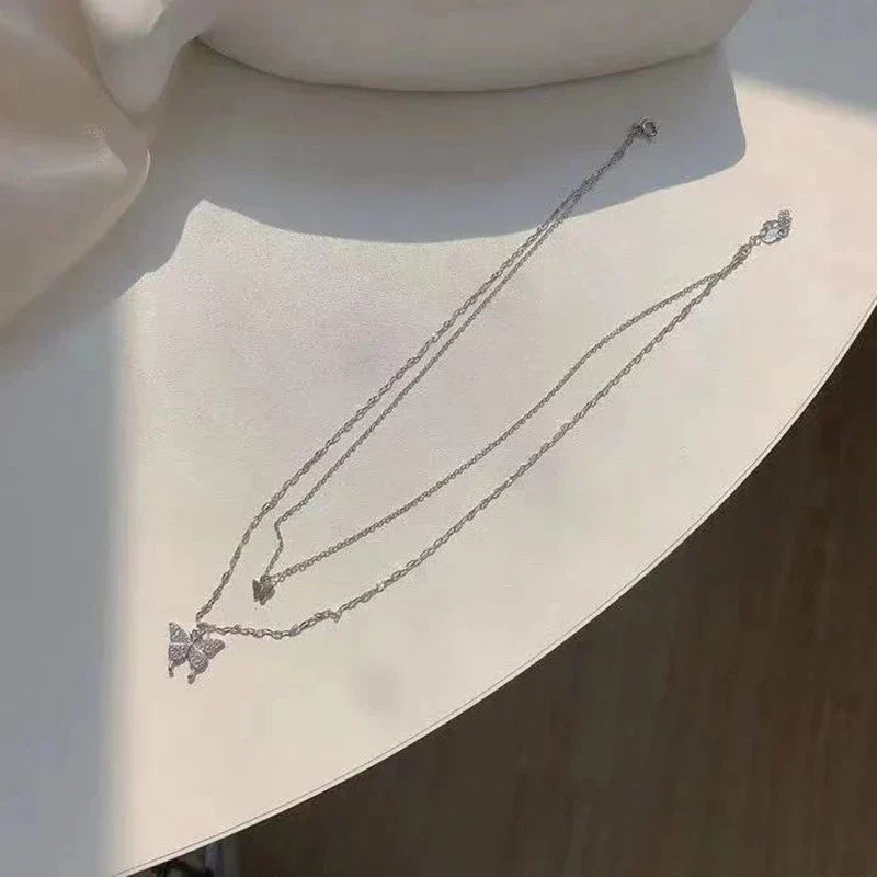 Collier femme avec papillon zircon. Pendentif brillant sur double chaîne argent, bijou élégant et tendance.