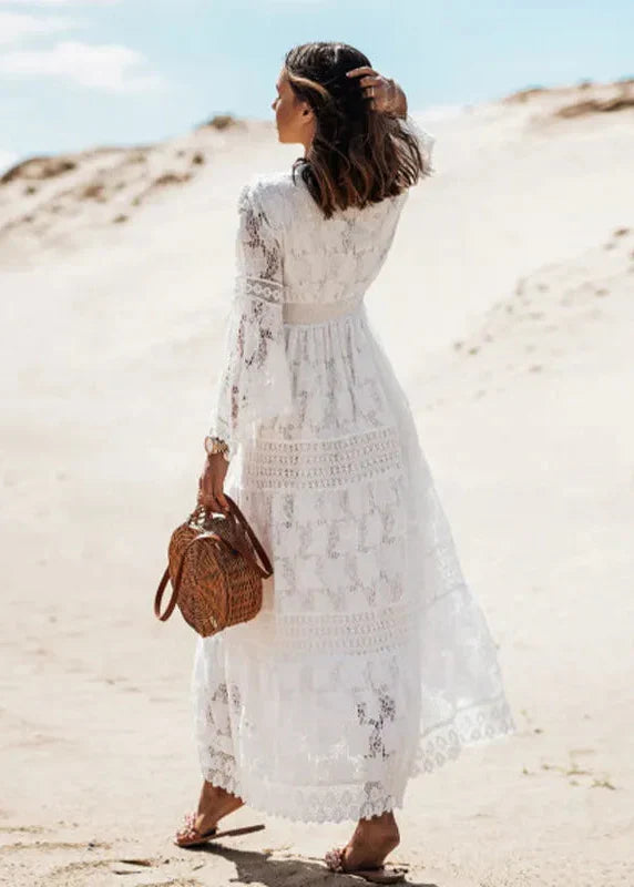 Élégante robe longue blanche femme. Coupe fluide, col en V plongeant et manches évasées pour un look bohème chic.