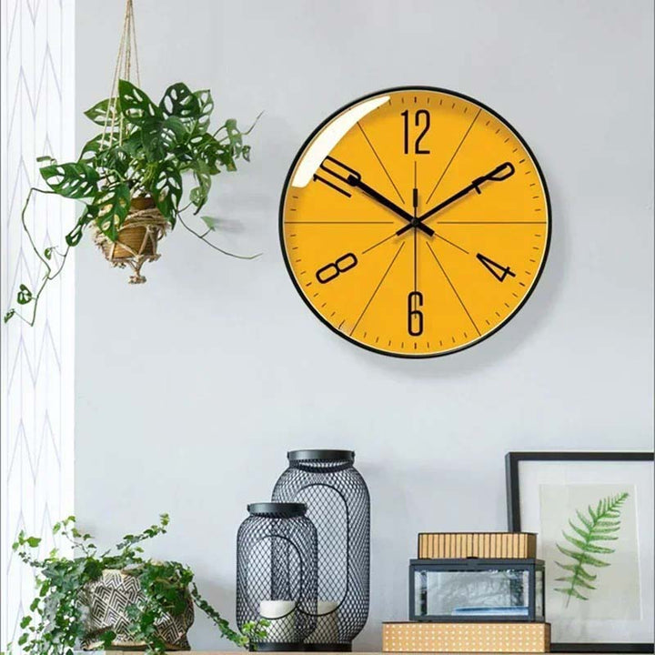 Horloge murale ronde design jaune avec aiguilles noires contrastantes. Mouvement quartz silencieux.