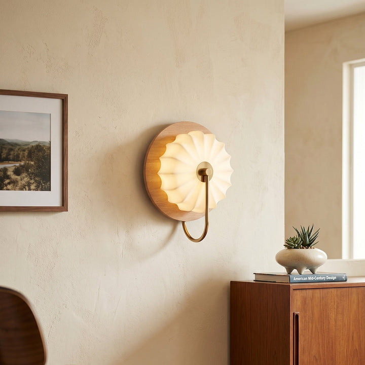 Détail de l'applique murale avec abat-jour en tissu et base en bois. Lumière chaude.