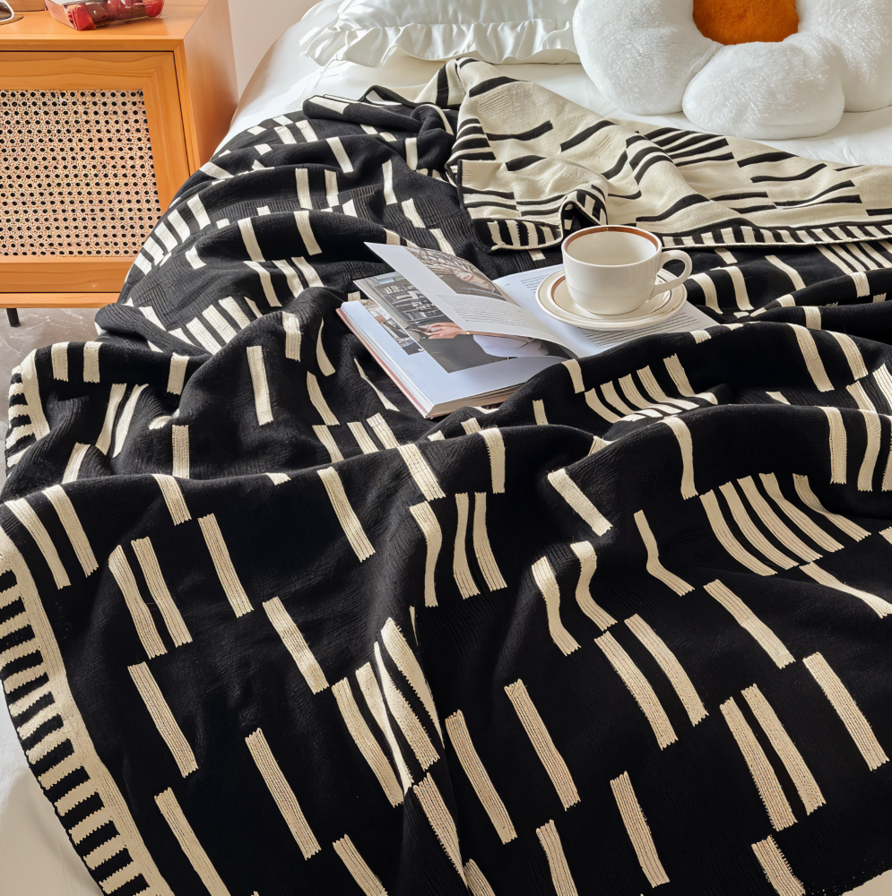 Plaid multi-usage tricoté noir et beige, confortable pour lit, canapé, ou comme jeté décoratif doux.