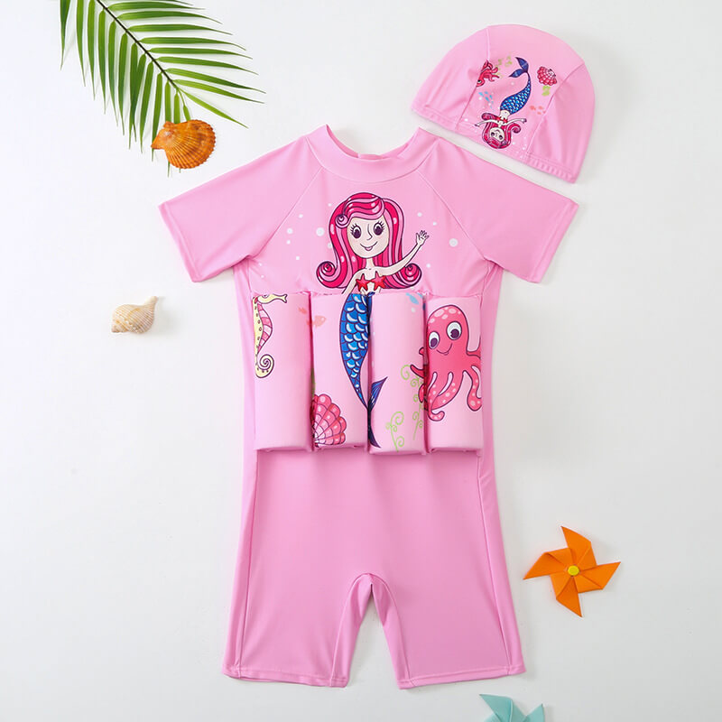 Enfant portant un maillot flottant SafeSwim vert, aide à la natation et jeu aquatique sécurisé.