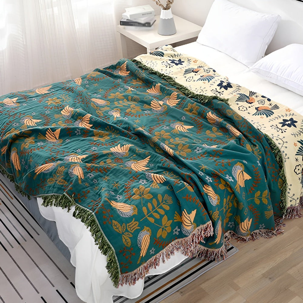 Plaid réversible en coton bohème avec motifs oiseaux et fleurs, idéal pour canapé ou lit.
