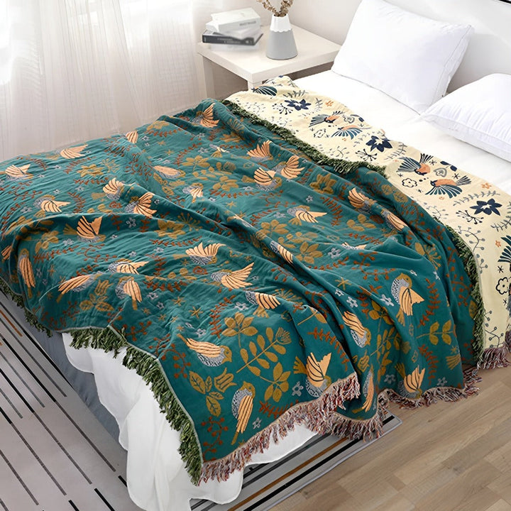 Plaid réversible en coton bohème avec motifs oiseaux et fleurs, idéal pour canapé ou lit.