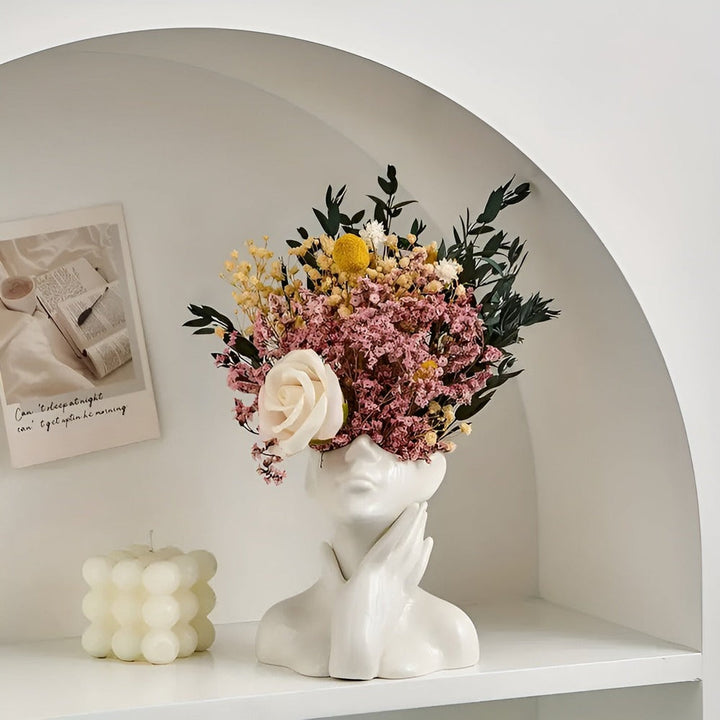 Gros plan sur le vase décoratif à visage, montrant l'expression artistique et les détails du design.