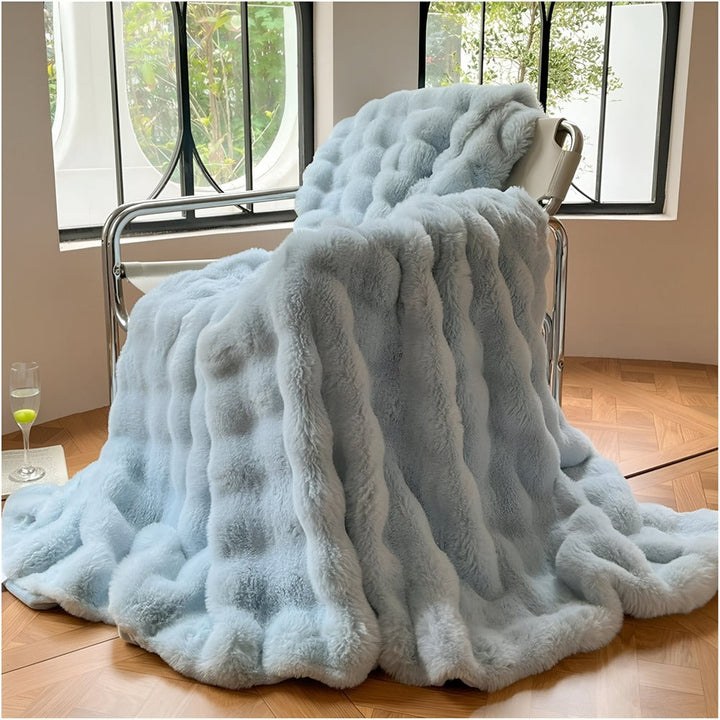 Détail de la fausse fourrure douce de la couverture polaire, promesse de chaleur et de cocooning.