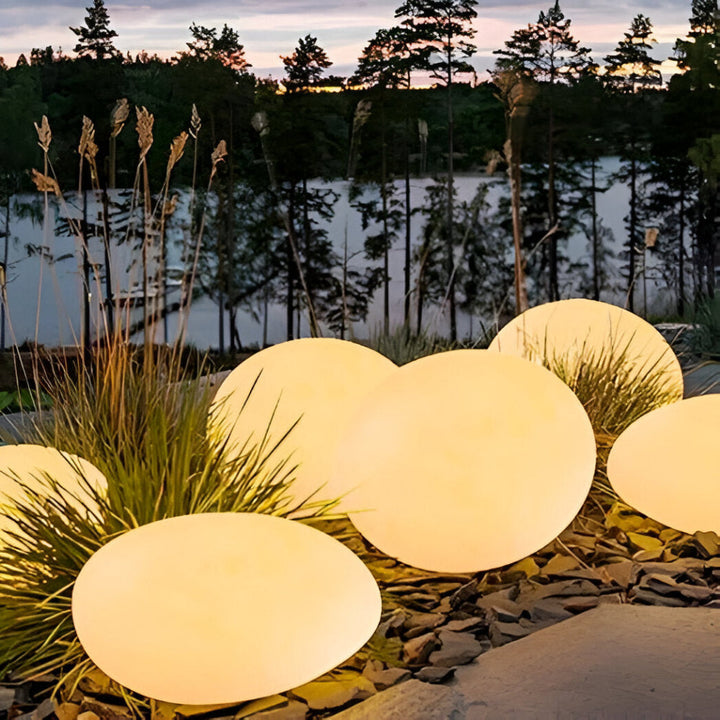 Lampe LED solaire robuste, aspect pierre, idéale pour balisage de jardin.