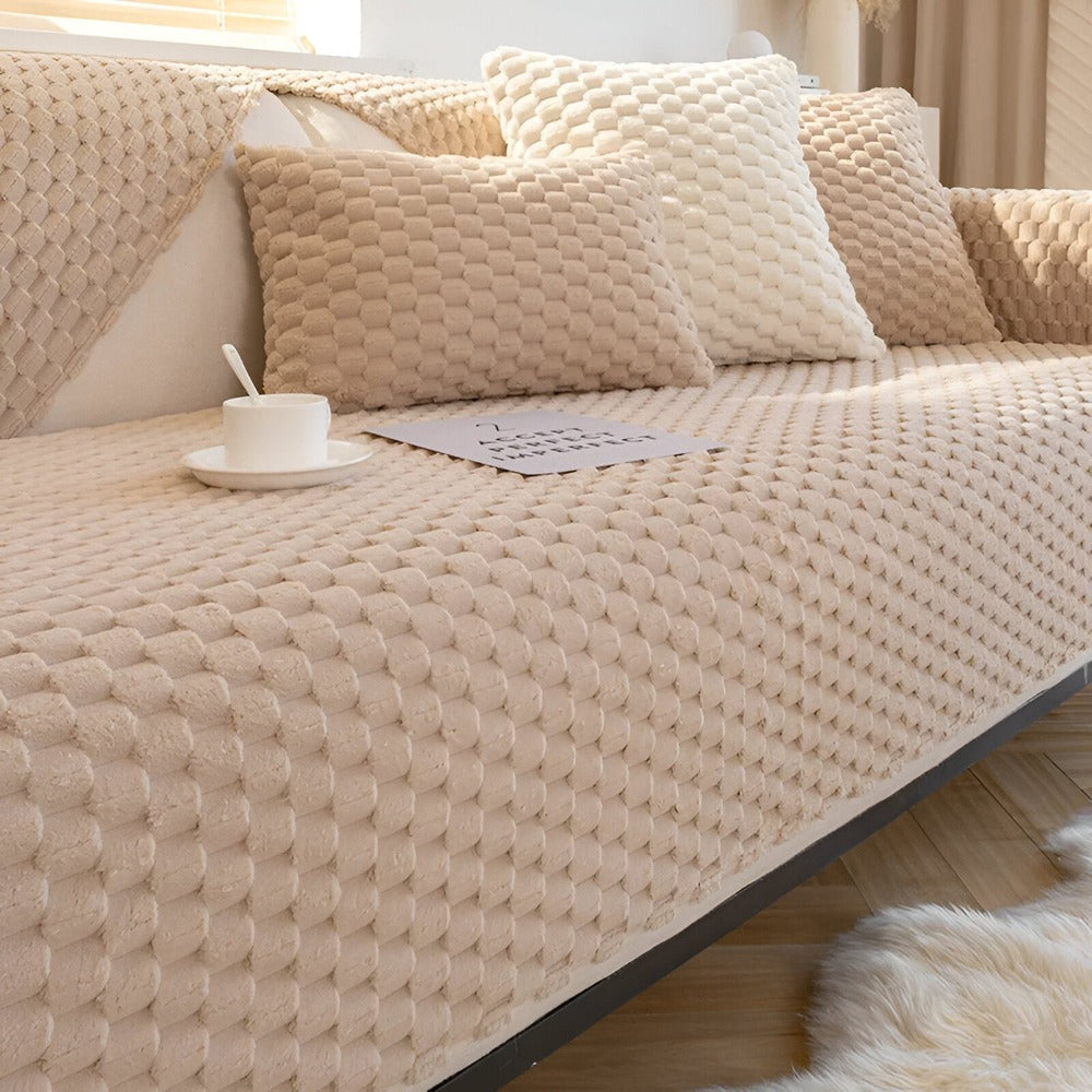 Détail du motif nid d'abeille sur une housse de canapé antidérapante. Texture douce et moderne pour protection.