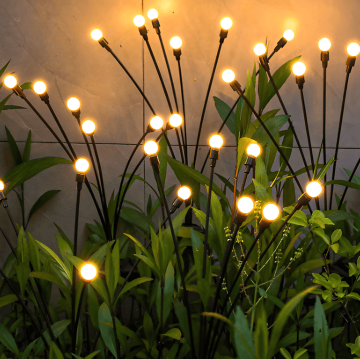 Lucioles solaires étanches illuminant un chemin de jardin la nuit, énergie solaire décorative.