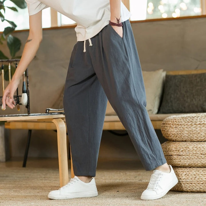 Mode homme: pantalon fuselé moderne à jambe raccourcie, confortable pour tenue urbaine décontractée avec cordon.