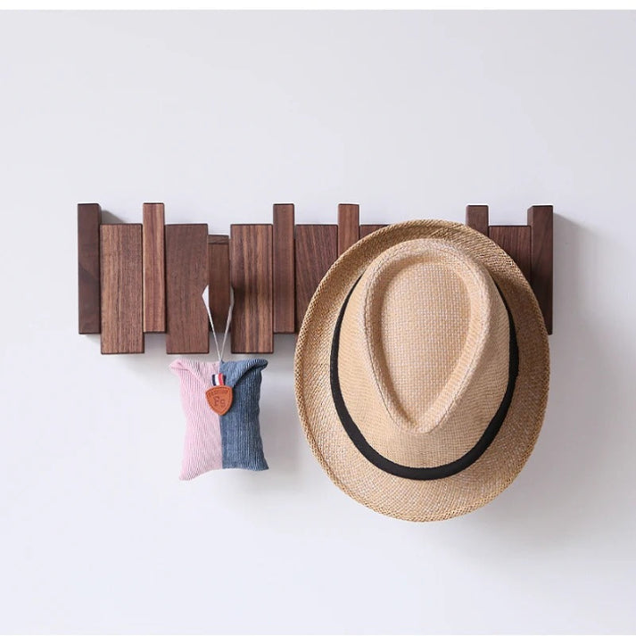 Porte-manteau mural en bois massif, crochets escamotables, design piano unique pour une entrée stylée.