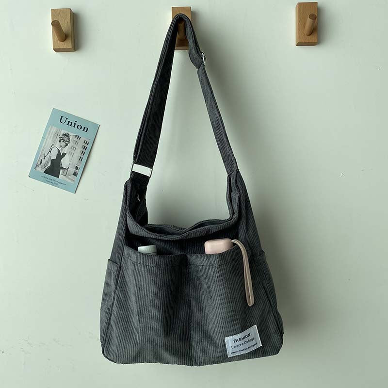 Sac bandoulière femme en velours côtelé marron, style rétro décontracté pour un look urbain élégant.