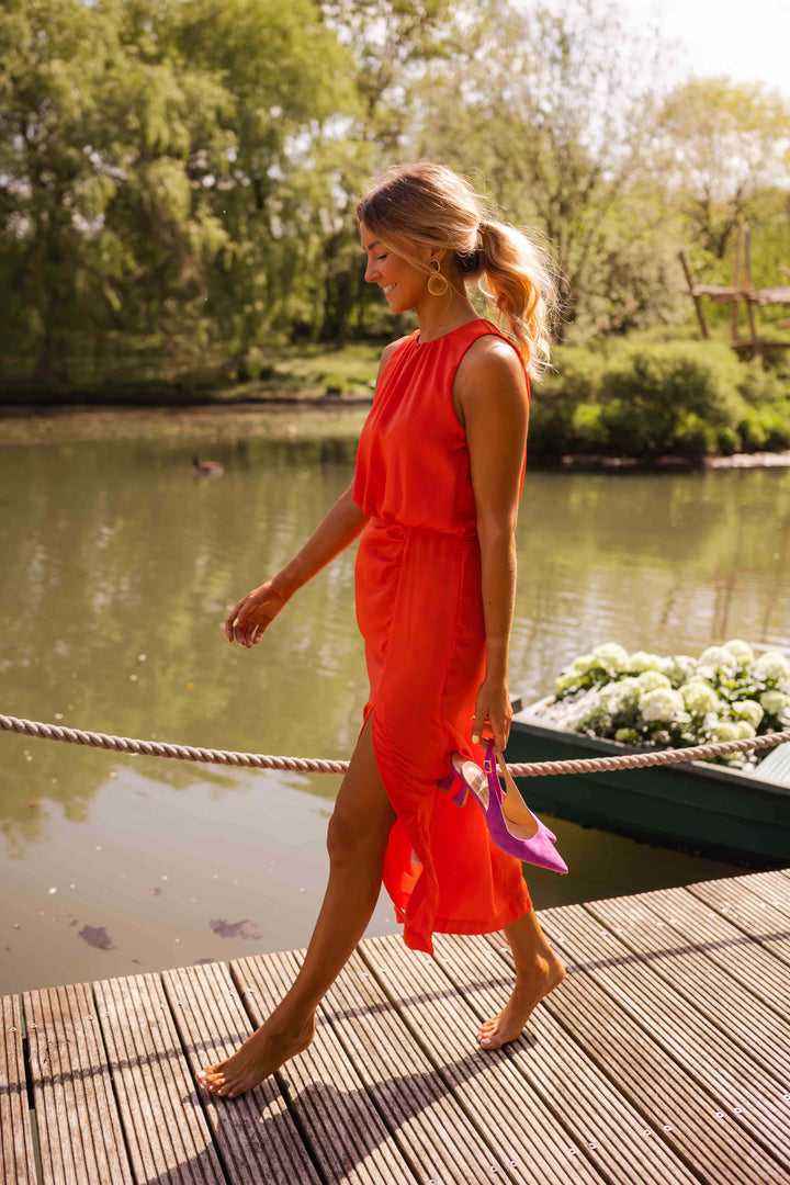 Robe élégante midi femme pour soirée ou été. Coupe sans manches, fente subtile, style mode femme.