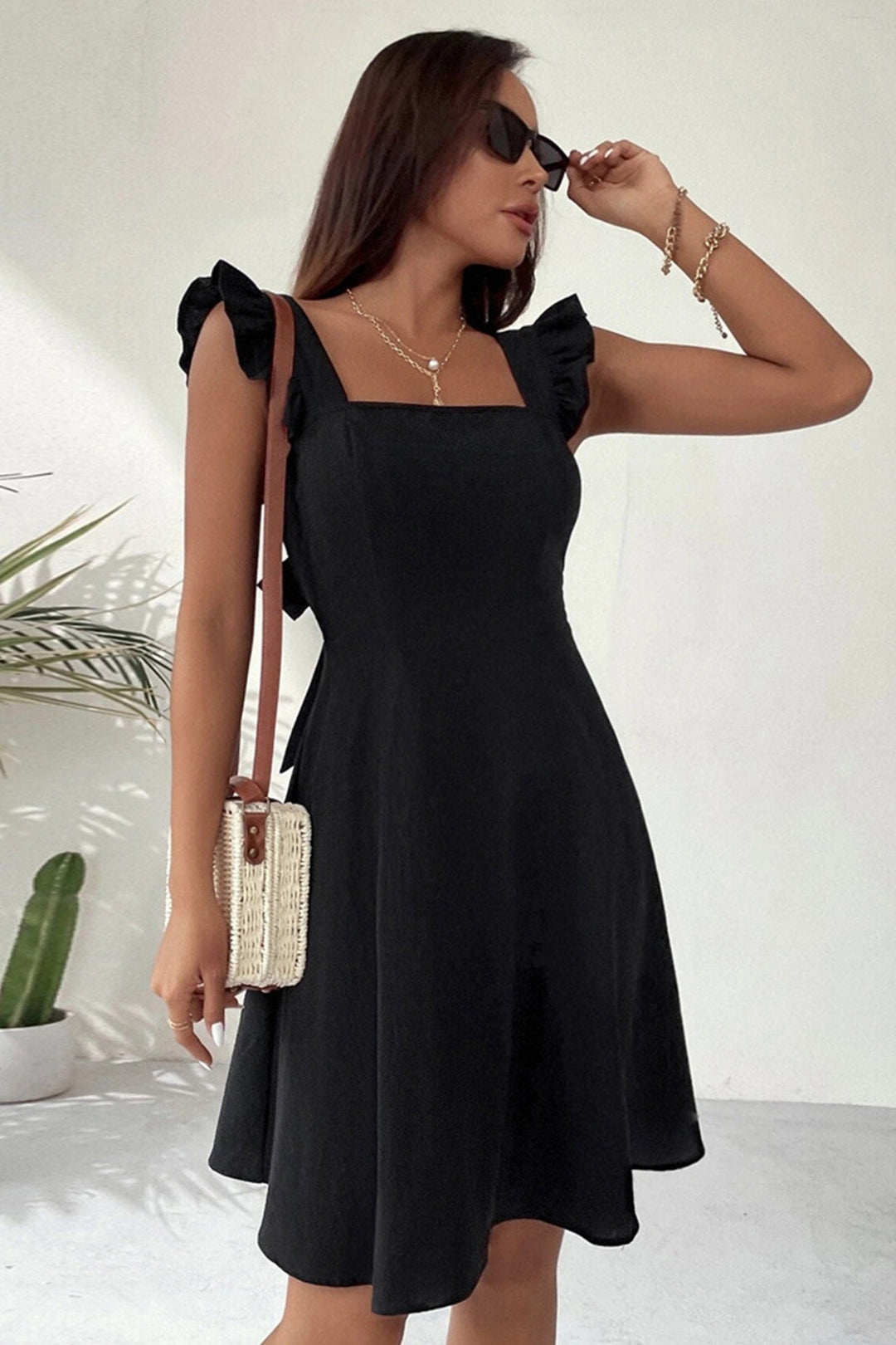 Mini-robe femme à volants, encolure carrée, dos noué. Pour des vacances stylées.