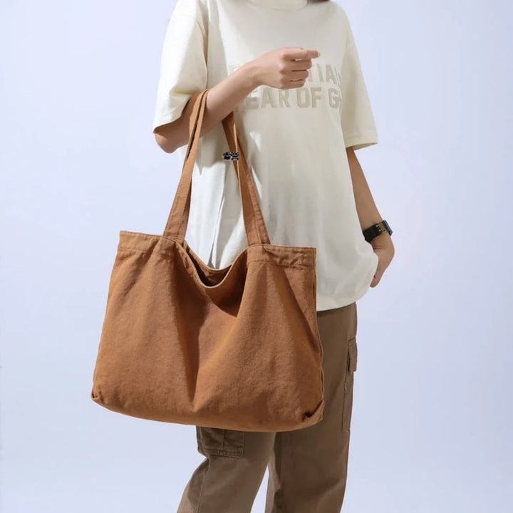 Femme élégante portant un grand sac cabas en coton. Accessoire mode quotidien pratique et spacieux.