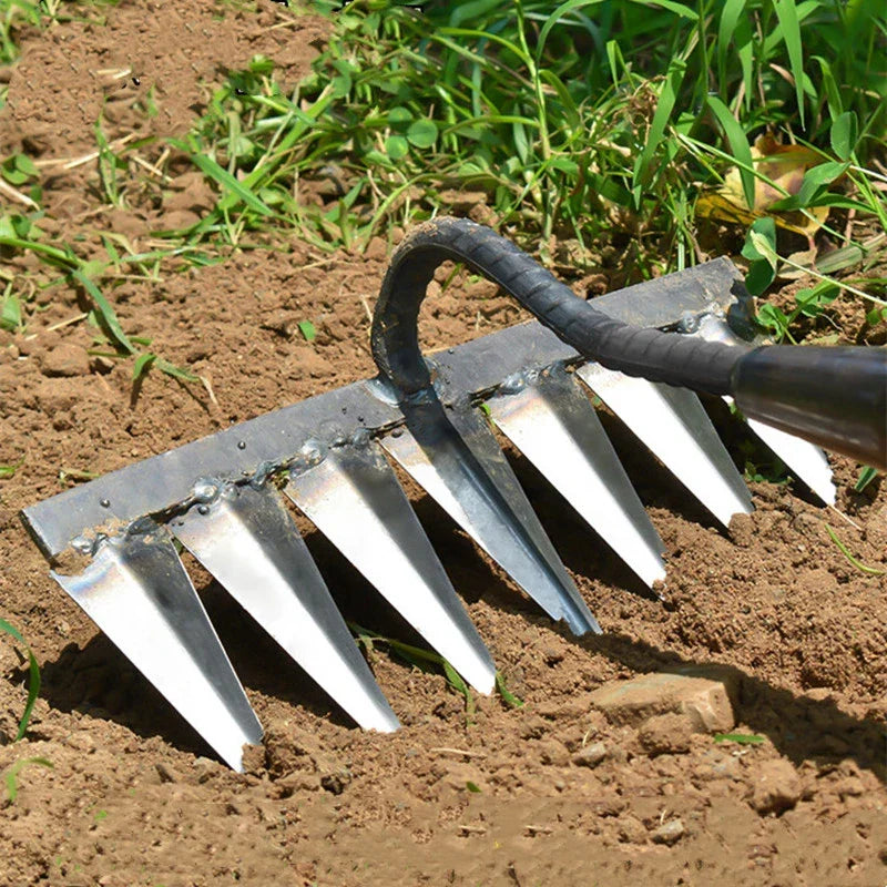 Jardinier utilisant le scarificateur LuxHarrow en acier inoxydable pour aérer et désherber un parterre.
