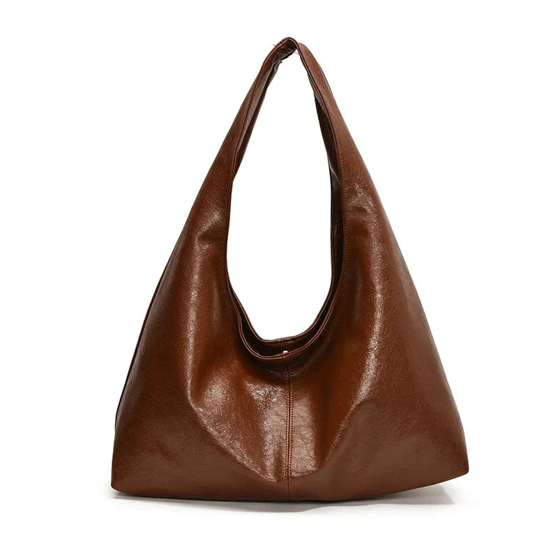 Sac à main hobo crème, porté sur l'épaule, accessoire chic, spacieux et confortable.