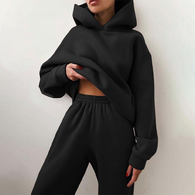 Ensemble femme sportswear décontracté. Sweat à capuche et pantalon loose fit pour un confort loungewear optimal.