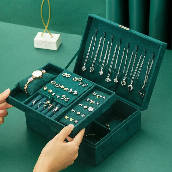 Intérieur d'une boîte à bijoux en velours rose, compartiments dédiés, organisateur pratique et élégant.