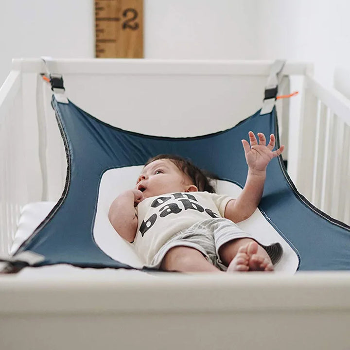 Lit bébé DreamNest bleu, offrant un sommeil serein et sécurisé, parfait cocon pour nouveau-né.