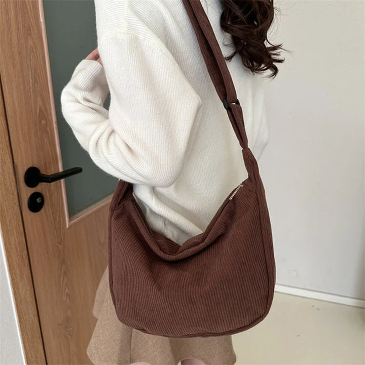 Sac banane velours rose poudré, féminin et tendance, accessoire pratique pour un look hivernal stylé.