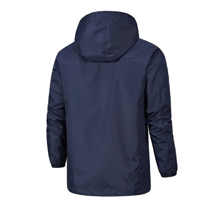 Homme portant une veste imperméable coupe-vent à capuche, marchant en extérieur. Idéal randonnée, loisirs.