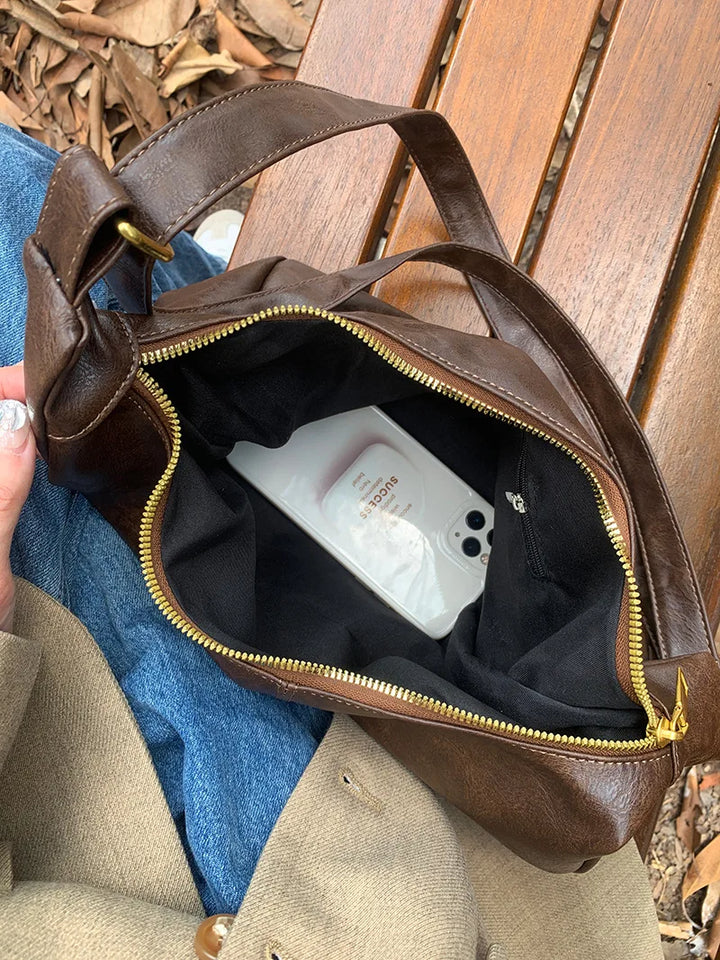 Femme élégante portant le sac à main bandoulière en similicuir. Accessoire mode tendance pour un look moderne.