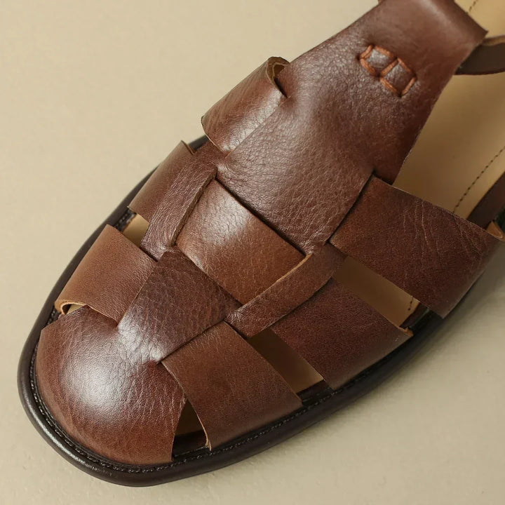Détail des sandales T-strap Marivelle noires pour femmes, design plat, alliant confort et élégance estivale.