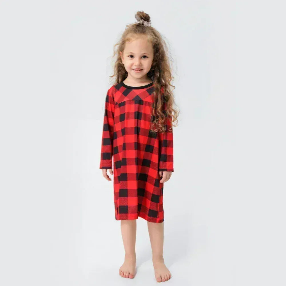 Gros plan sur le tissu doux d'un pyjama de Noël à carreaux, symbolisant le confort et l'esprit festif.