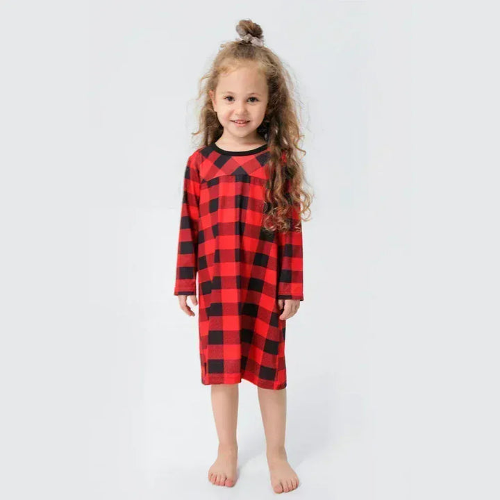 Gros plan sur le tissu doux d'un pyjama de Noël à carreaux, symbolisant le confort et l'esprit festif.