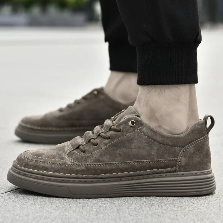 Paire de baskets hommes élégantes, posée sur un fond neutre, prête à être portée.