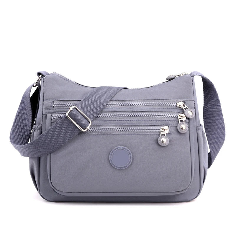 Sac bandoulière multifonction femme, nylon léger, parfait pour le voyage et l'usage quotidien.