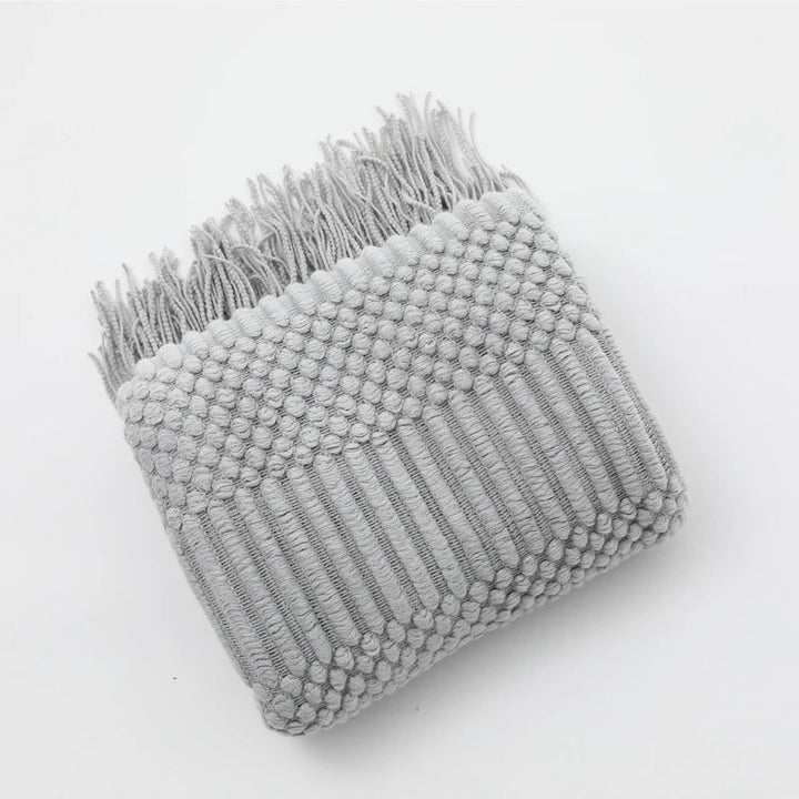 Jeté de canapé tricoté motif bohème, transformant l'espace avec chaleur et une touche de style unique.