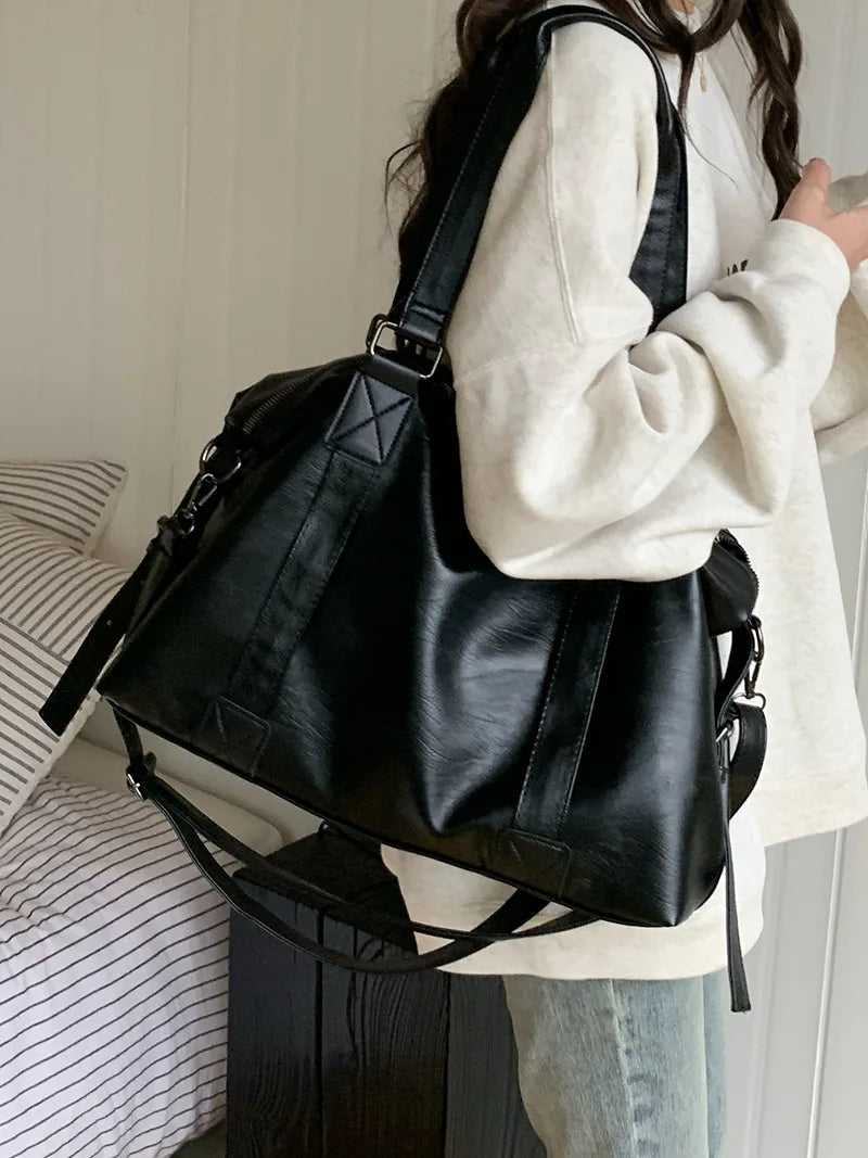 Sac épaule femme polyvalent en similicuir noir, peut être porté en bandoulière, spacieux et organisé.