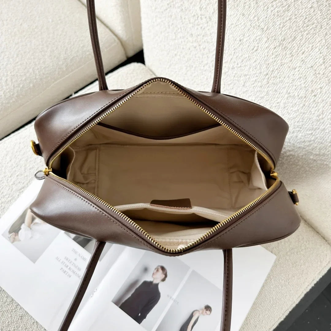 Femme élégante portant un sac épaule chic en cuir marron, accessoire mode parfait pour un look sophistiqué.