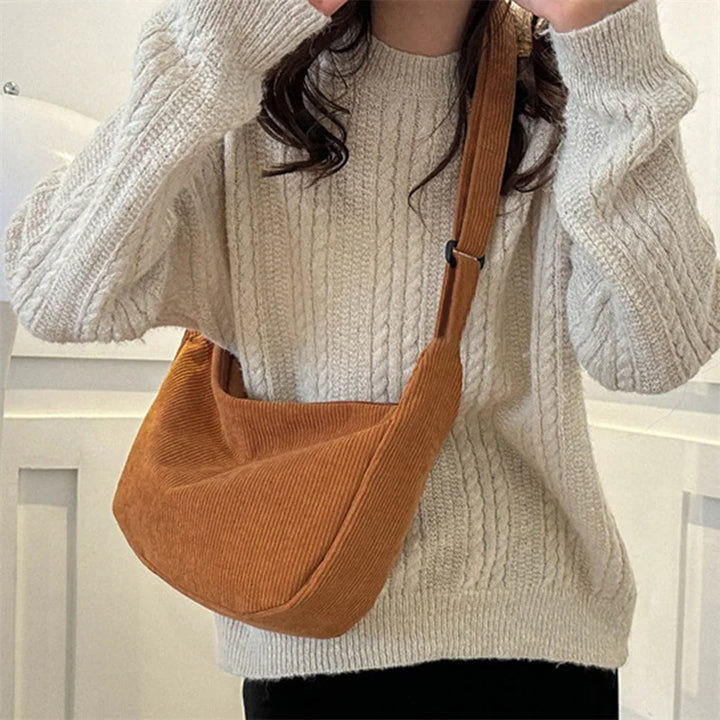 Sac banane velours femme noir, accessoire mode tendance et pratique pour l'hiver, porté en bandoulière.