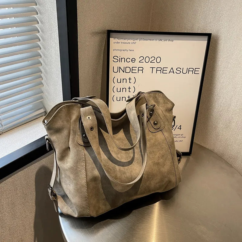 Sac à main en daim élégant pour femme, avec bandoulière réglable, un incontournable de la mode.